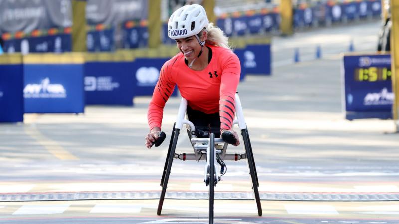 A female wheelchair racer crossing the finish line at the New York City Marathon