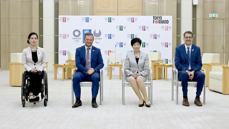 Four people in official attire, two men and two women, pose for a photo.