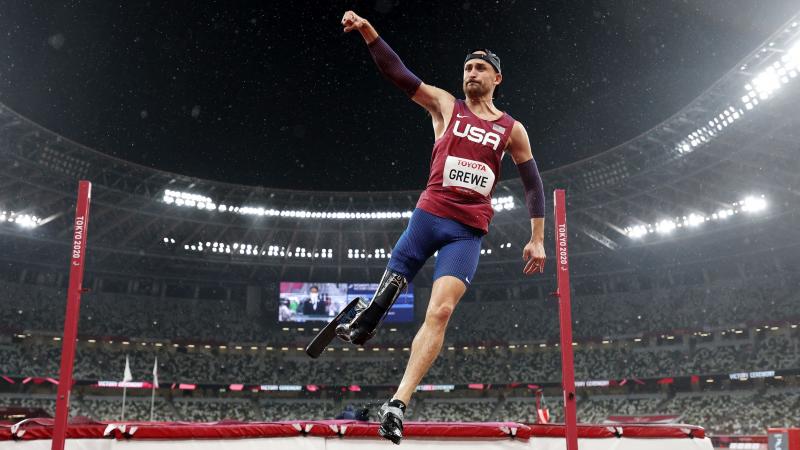 A male high jumper raises his right fist in celebration after winning his event at the Tokyo 2020 Paralympic Games.