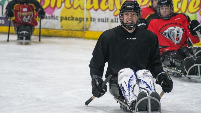 A group of four female Para ice hockey players on an ice rink