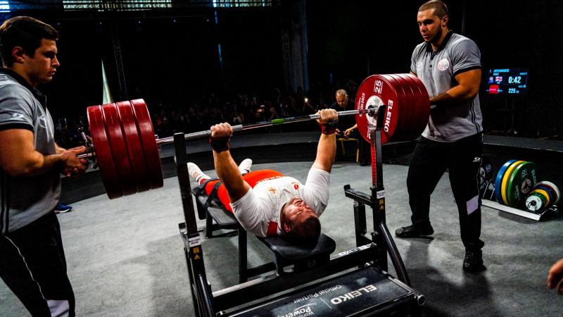 A heavyweight powerlifter prepares to make a lift with the audience watching on.