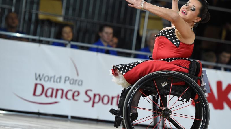 A female wheelchair dancer with a red dress during a competition