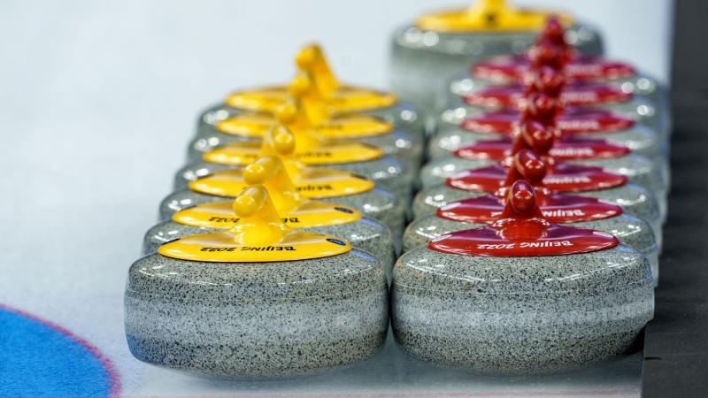Two rows of Beijing 2022 curling stones marked on the ice.
