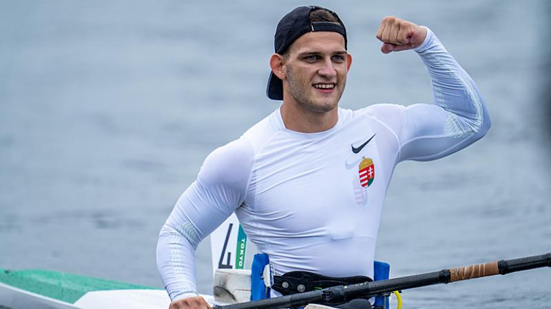 A male athlete in a kayak pumps his fist