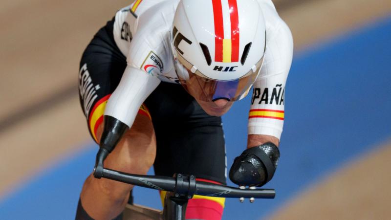 A male athlete wearing a helmet rides a bicycle at the Tokyo 2020 Paralympic Games.