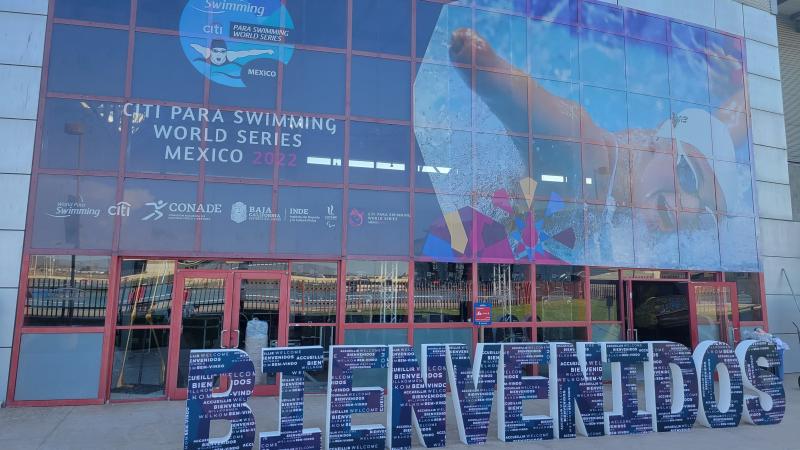 The entrance of an aquatics centre with the Bienvenidos message in front of the doors