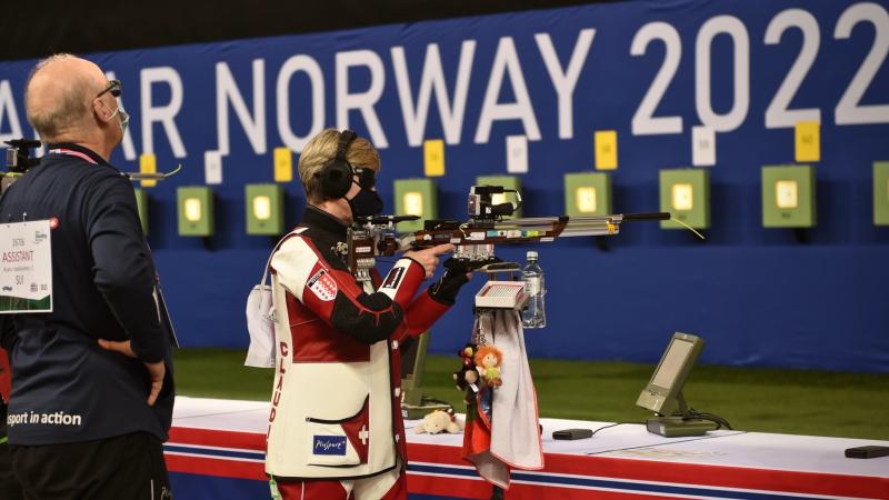 A female vision impaired shooter and her assistant in a competition