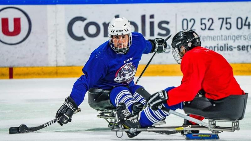 Two male Para ice hockey players competing on ice