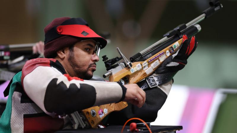 A male shooter with a rifle in a shooting range