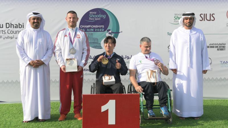 The medallists of P1- men's 10m air pistol SH1 poses with their medals on the podium of the Al Ain 2022 World Shooting Para Sport Championships.