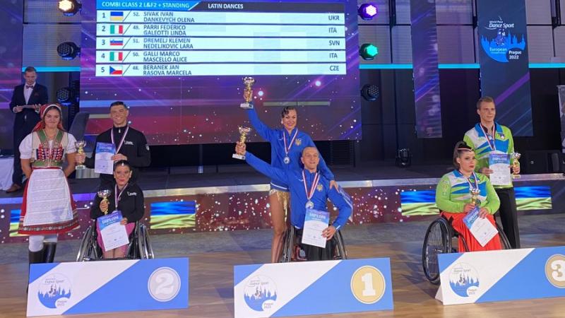 Ukraine's Ivan Sivak (centre) poses on the podium with his dance partner Olena Dankevych after taking the combi class 2 gold medal.