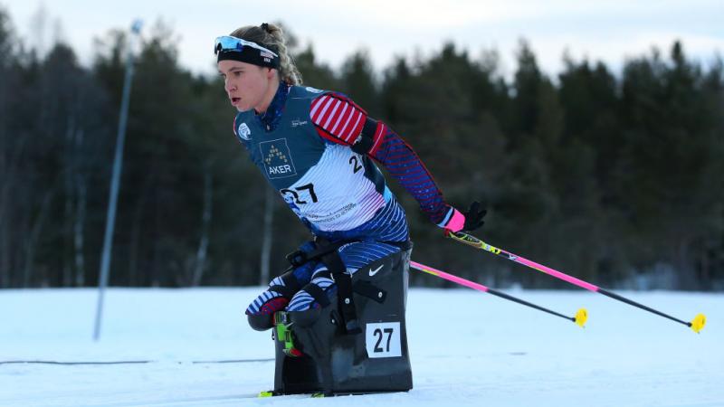 A female athlete on a sit-ski competes at the World Para Snow Sports Championships