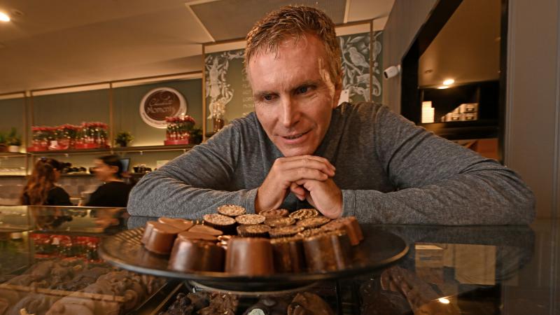 A man stands in front of a display of chocolates