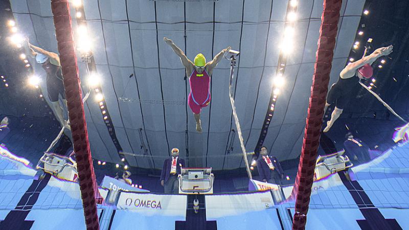 An underwater image of three female Para swimmers jumping in the water at the Tokyo 2020 Paralympic Games