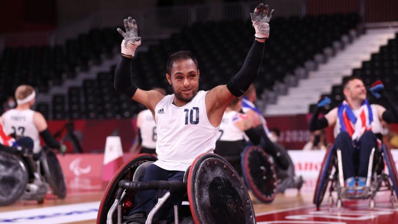 A male wheelchair rugby player raises both hands in celebration at the Tokyo 2020 Paralympic Games.
