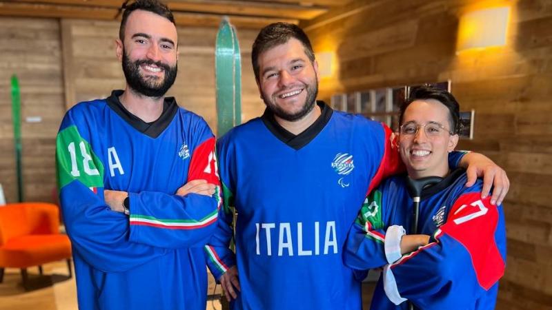 Three men wearing Italy's Para ice hockey jersey posing for a picture