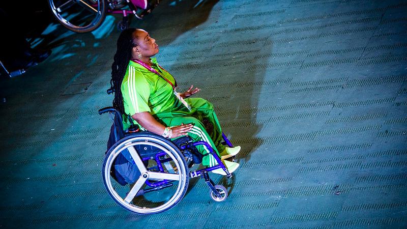 A woman in a wheelchair with a green Nigerian shirt