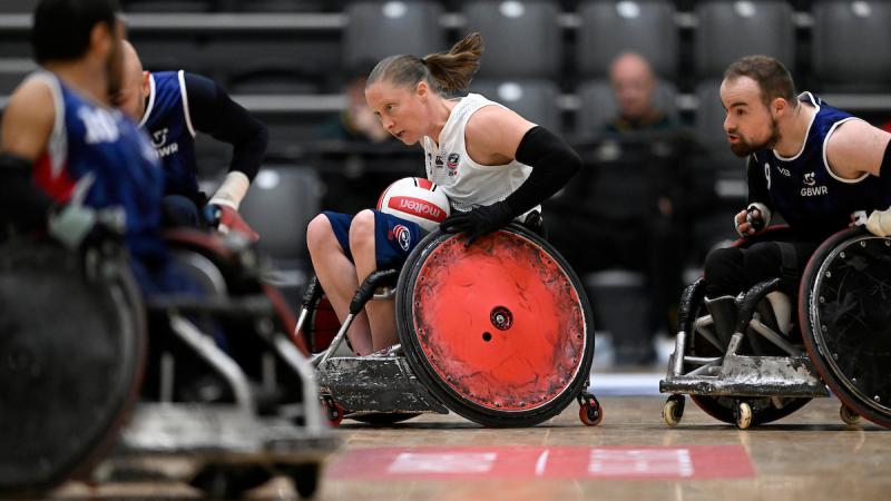 A female wheelchair rugby athlete plays with male players.