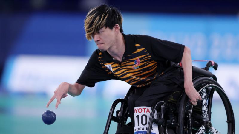 A male boccia athlete throws a blue ball at the Tokyo 2020 Paralympic Games.