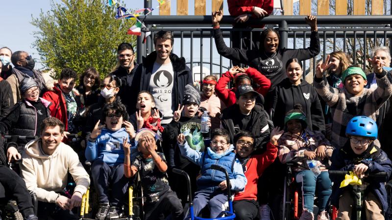 A group photo of about 20 people, including children using wheelchairs