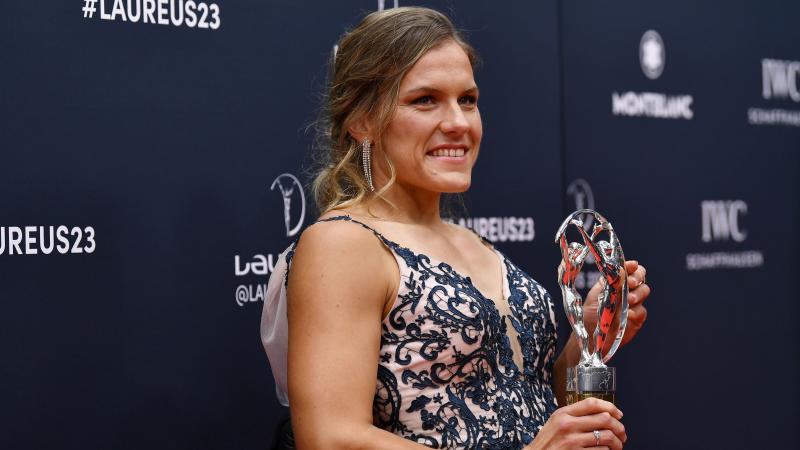 A female athlete holds a silver trophy