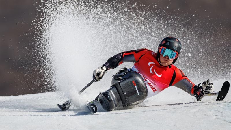 A male athlete competes on a sit-ski.