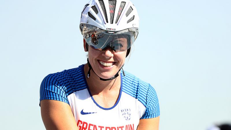 A female athlete with a helmet smiliing