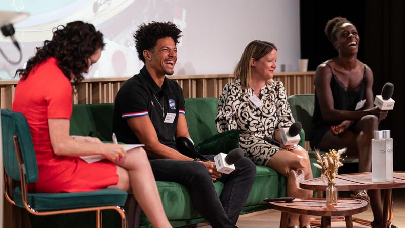 Four female and male Paralympians speak on stage.