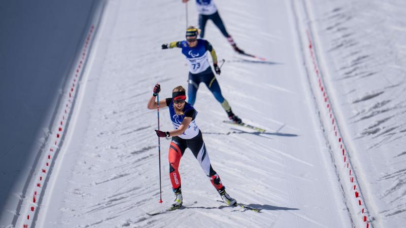 Three female cross-country skiers compete at Beijing 2022.