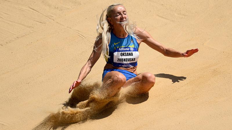 A female long jumper landing on the sand box