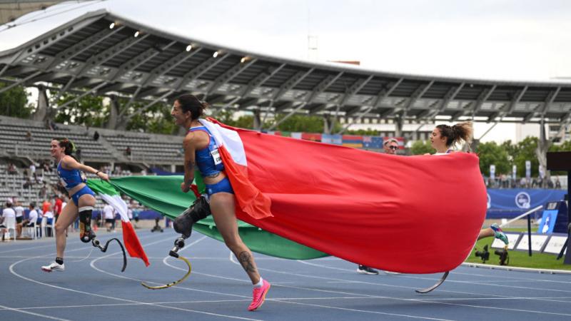 Martina Caironi Ambra Sabatini Monica Graziana running with a giant Italian flag