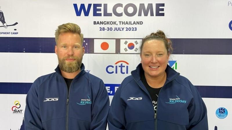 A man and a woman standing in front of a Welcome backdrop 