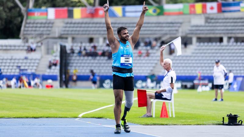 A men with a prosthetic leg celebrating on an athletics track