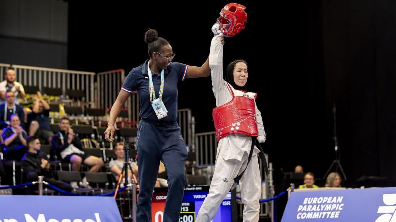 A female coach celebrates with a female Para taekwondo athlete