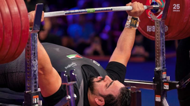 A man lifting a bar on a bench press