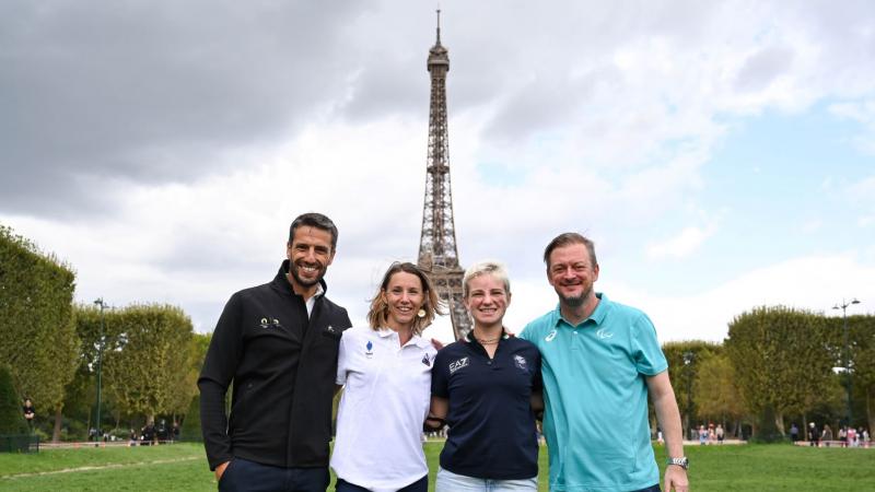 Four people pose for a photo in front of the Eiffel Tower