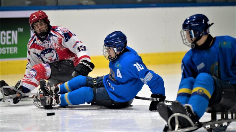 A Para ice hockey player trying a pass in front of other two players