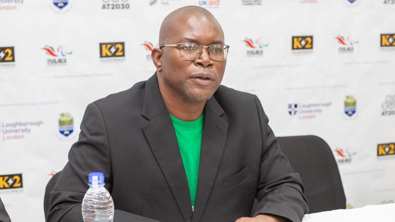 a man in glasses speaking at a press conference 