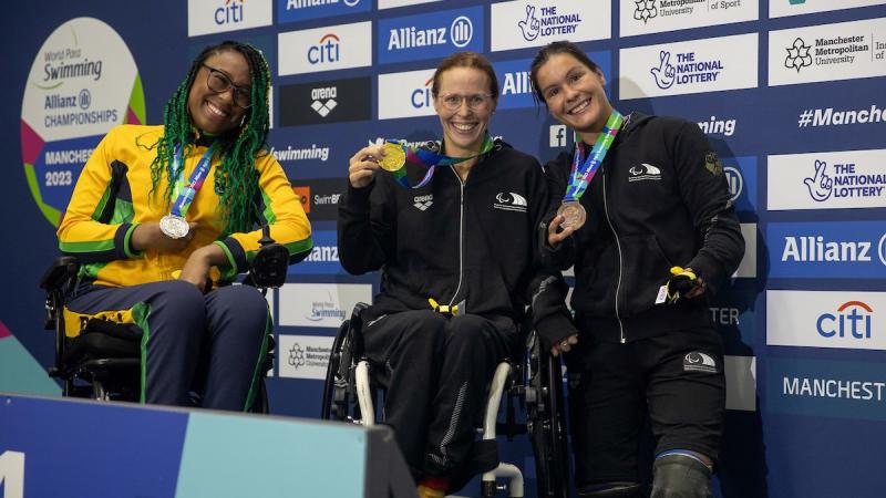 Three women on a podium with their medals