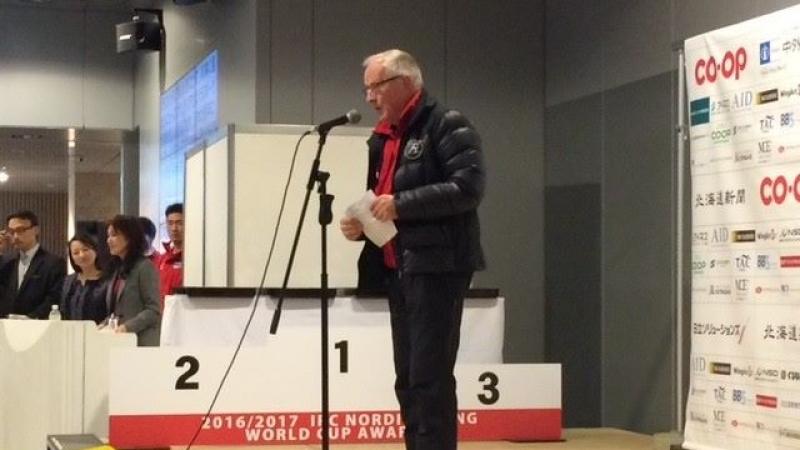 a man standing on a stage speaking into a microphone