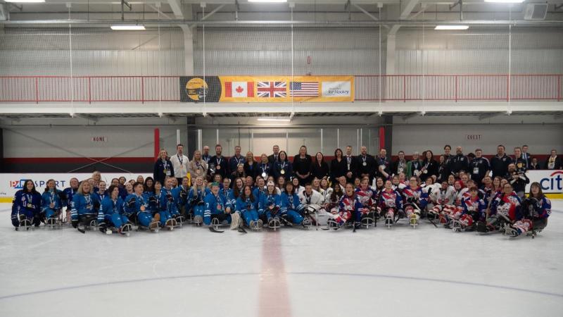 Four women's Para ice hockey teams posing for a picture on an ice rink