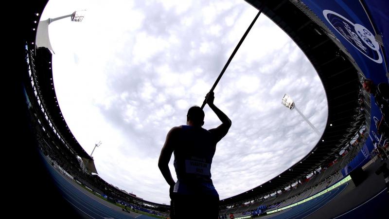 A male javelin thrower in a athletics stadium