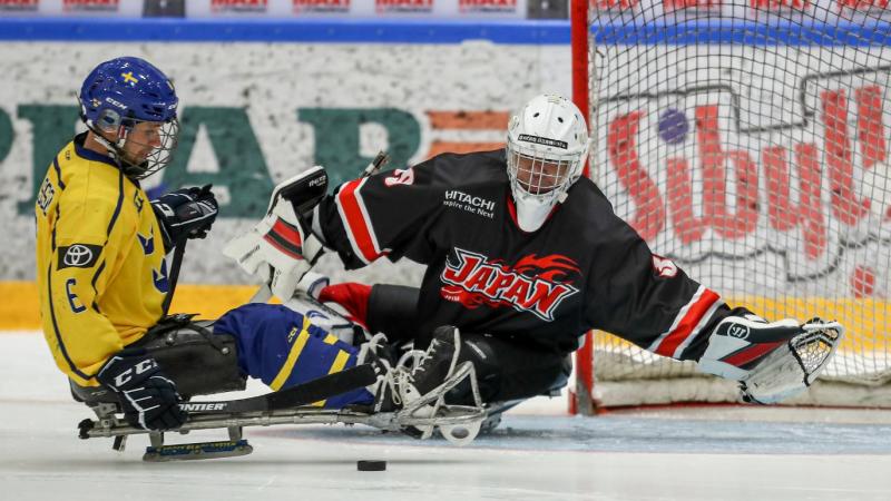 A Para ice hockey player taking a shot in front of the goaltender