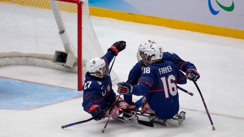 Three USA Para ice hockey players celebrating a goal