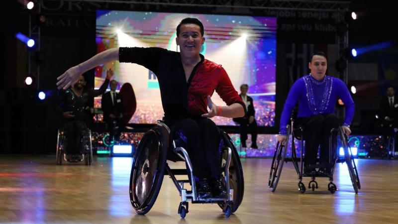 A male wheelchair dancer in a competition with another male dance in the background