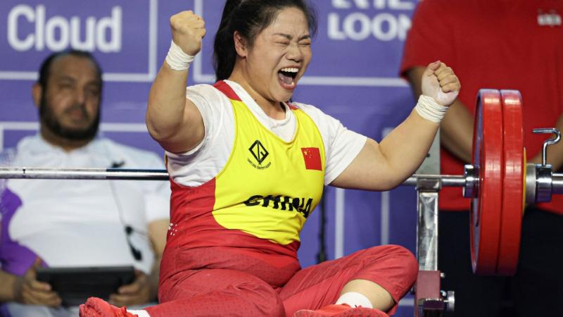 A female powerlifter celebrating on a bench press