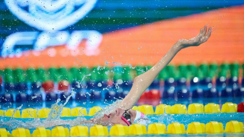 A male swimmer with a disability in his right arm in a swimming pool 