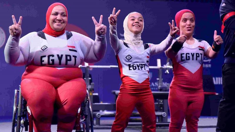 Women powerlifters celebrate.