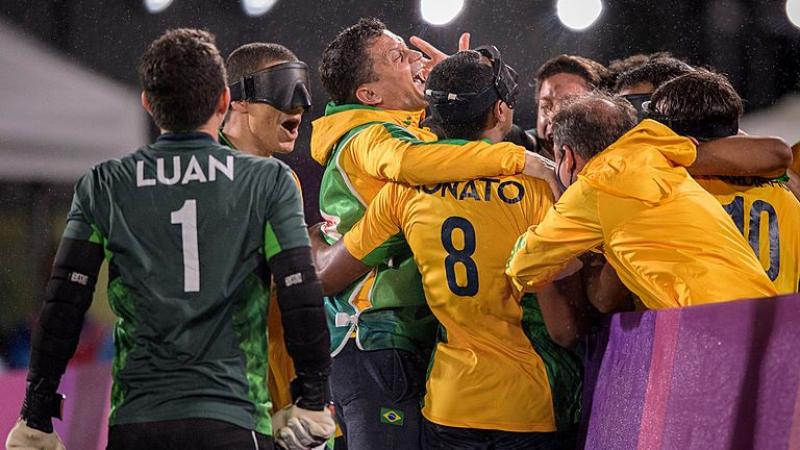 Eight blind football athletes gather to celebrate at the Tokyo 2020 Paralympics.