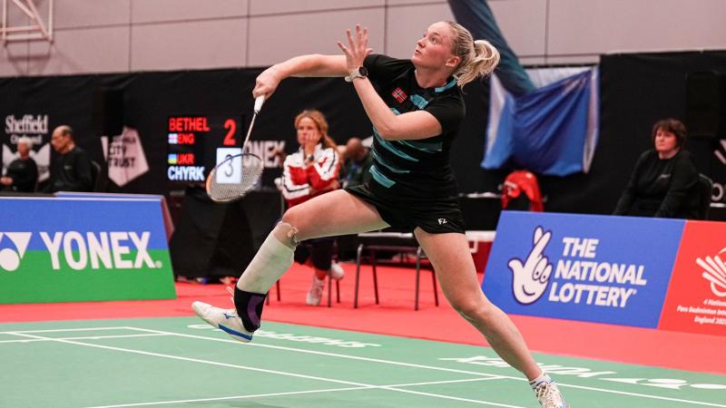 A female Para badminton player competes in a tournament.